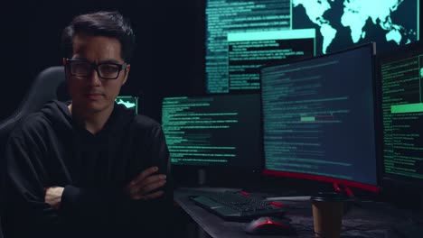 asian man hacker pose with code on multiple computer screens
