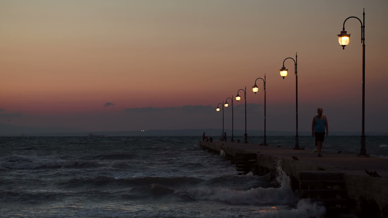 gente caminando y estadiendo en el muelle por la noche