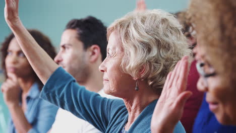 Woman-Asking-Question-At-Neighborhood-Meeting-In-Community-Center