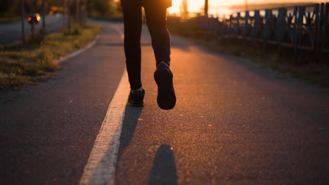 tracking shot with legs of a man running early in the morning on the sidewalk