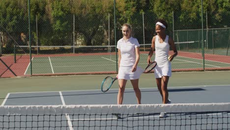 Video-of-happy-diverse-female-tennis-players-holding-rackets-and-talking