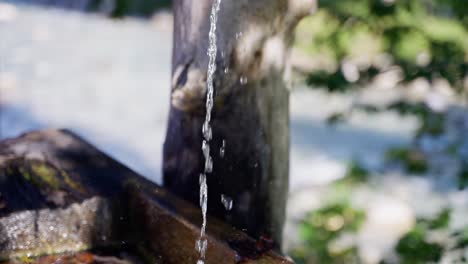 Brunnenwasser-Fließt-In-Zeitlupe-Aus-Holzklotzmulde-In-Alten-Trog,-Kamerafahrt