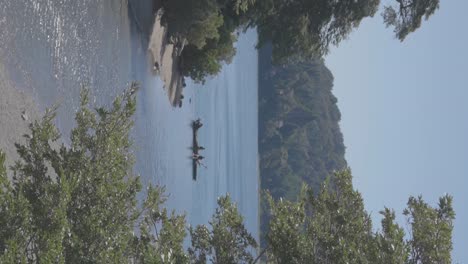 Relajándose-En-Un-Barco-De-Pesca-En-Un-Lago-En-Bariloche,-Patagonia,-Argentina-Cerca-De-La-Orilla-Del-Río-Rodeado-De-árboles-Boscosos