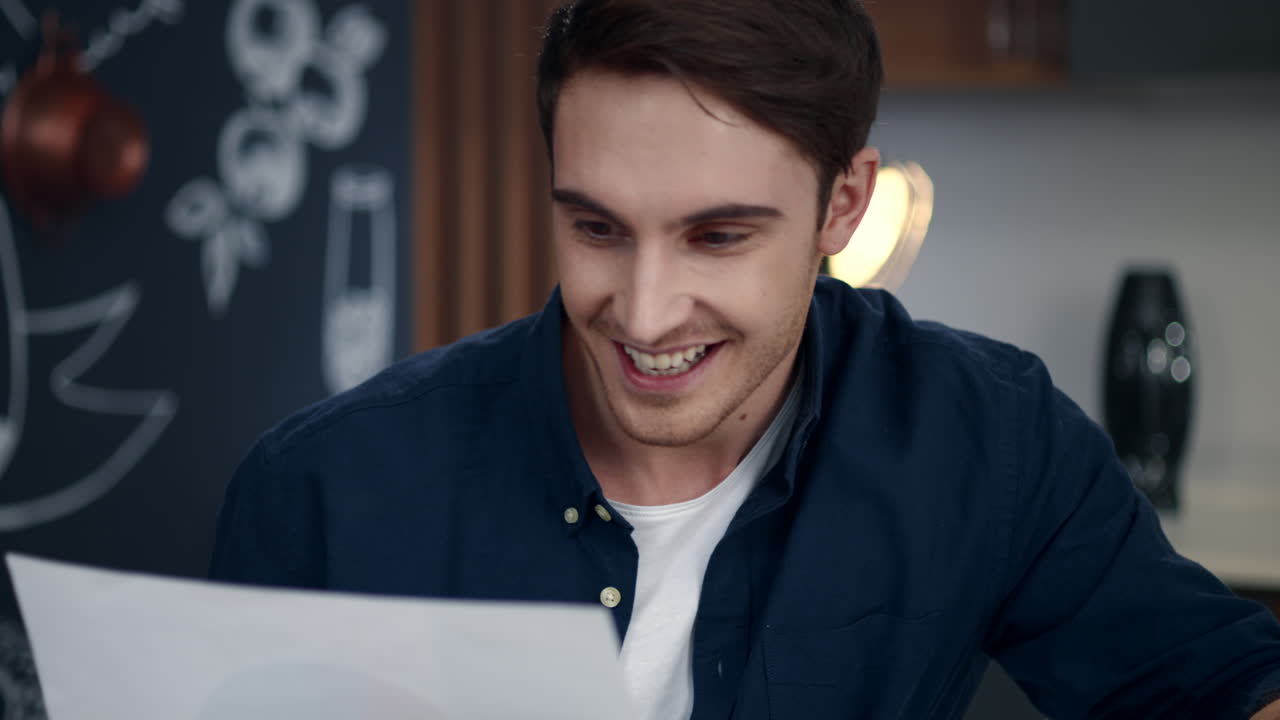 Portrait of surprised business man making yes gesture indoors