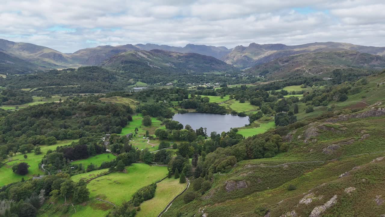 Aerial drone footage capturing sweeping views over Loughrigg Fell in the Lake District on a clear summer’s day