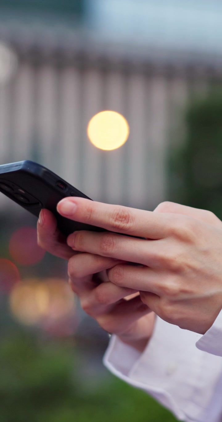 Primo piano di una persona che usa lo smartphone all'aperto di notte