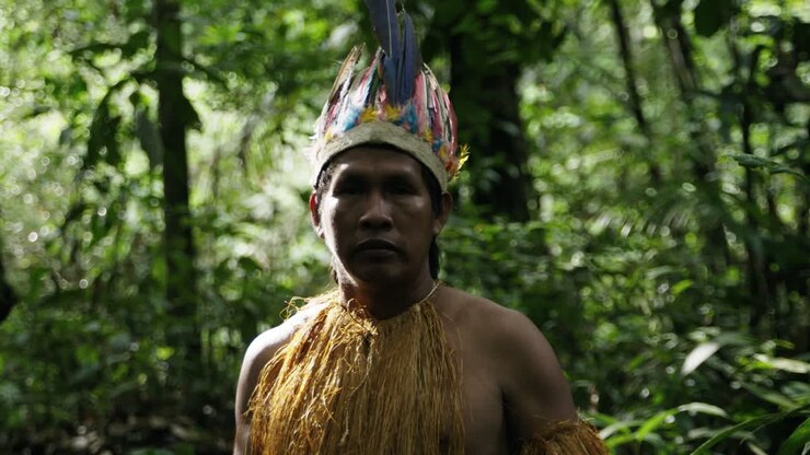 Portrait shot of an indigenous man in the dense jungle in Leticia, Amazon area, Colombia