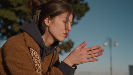 a tearful and unhappy woman sits alone, rubbing her hands gently in a gesture of deep thought. she is wearing a brown coat, and her head is slightly bent in contemplation, reflecting a somber mood