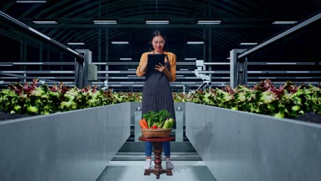 full body of asian female farmer with vegetable basket writing tablet in smart farm