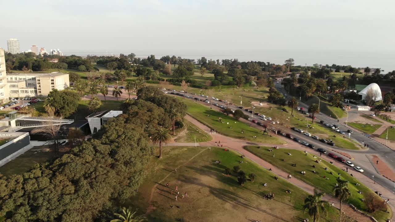 toma aérea de drones: paisaje del parque con gente jugando al fútbol en el fondo