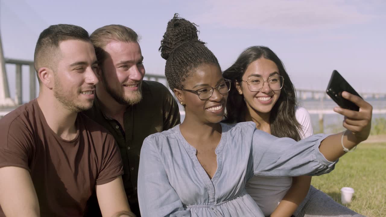 amigos sonrientes posando para una selfie en el parque