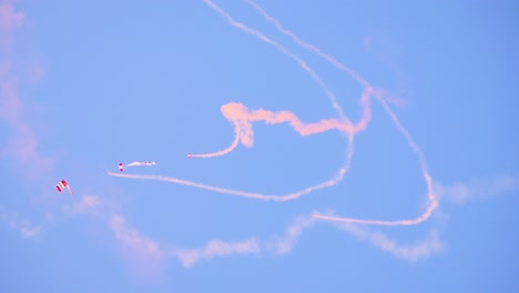 british red devils parachutists perform intricate maneuvers, leaving vibrant smoke trails in the sky during a military display