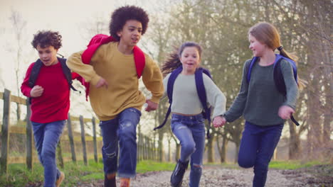 portrait children with school backpacks outdoors running along countryside track