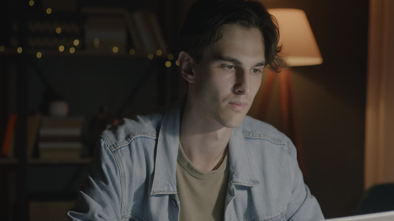 밤에 노트북으로 일하는 젊은 남자