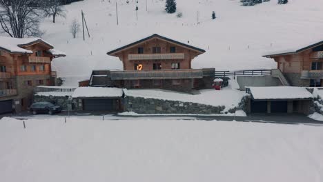 drone slowly flying towards a luxurious chalet in winter