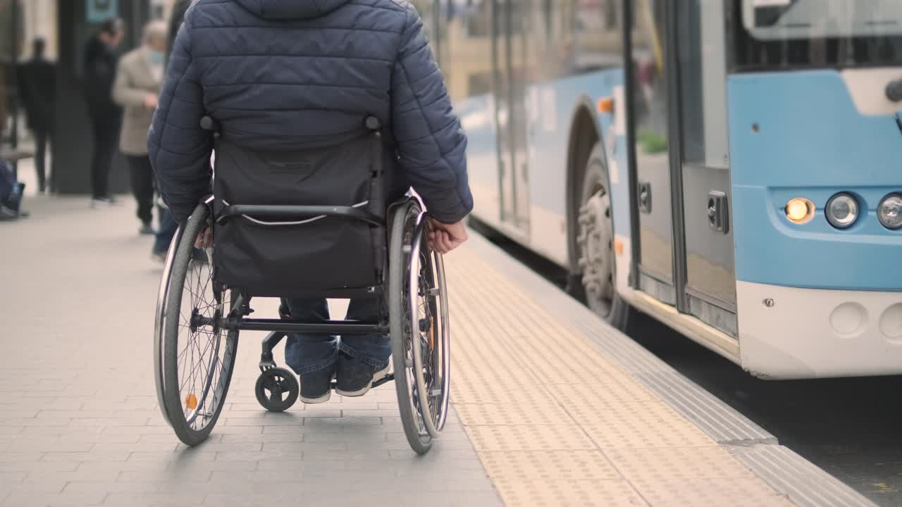 persona con discapacidad física que espera un transporte urbano con una rampa accesible