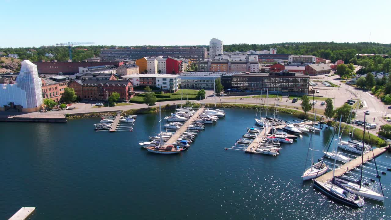 Immagine aerea di un porto turistico svedese che mostra imbarcazioni che si spostano verso un complesso di appartamenti in una giornata estiva