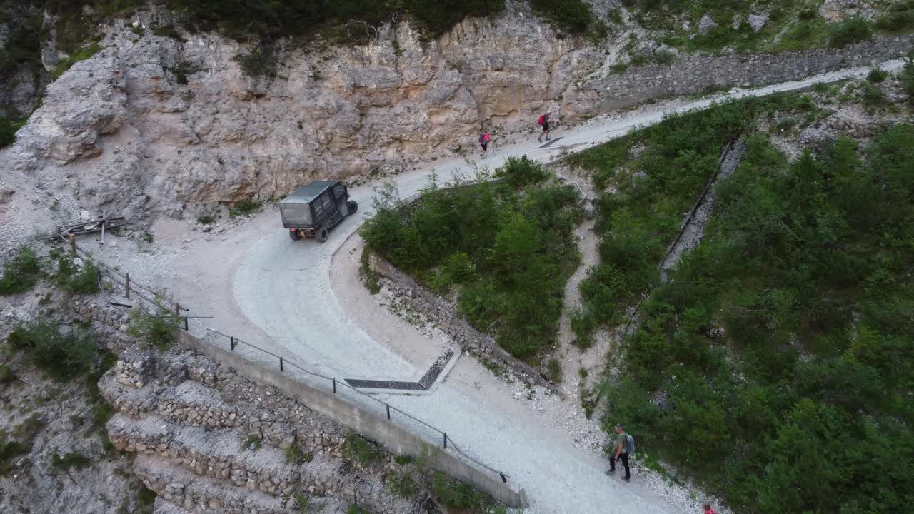 작은 전기 배달차가 대피소를 공급하기 위해 산을 올라갑니다.