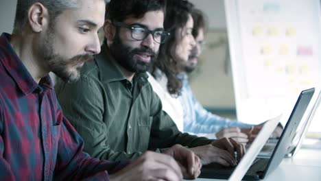 side view of confident programmers working with laptops