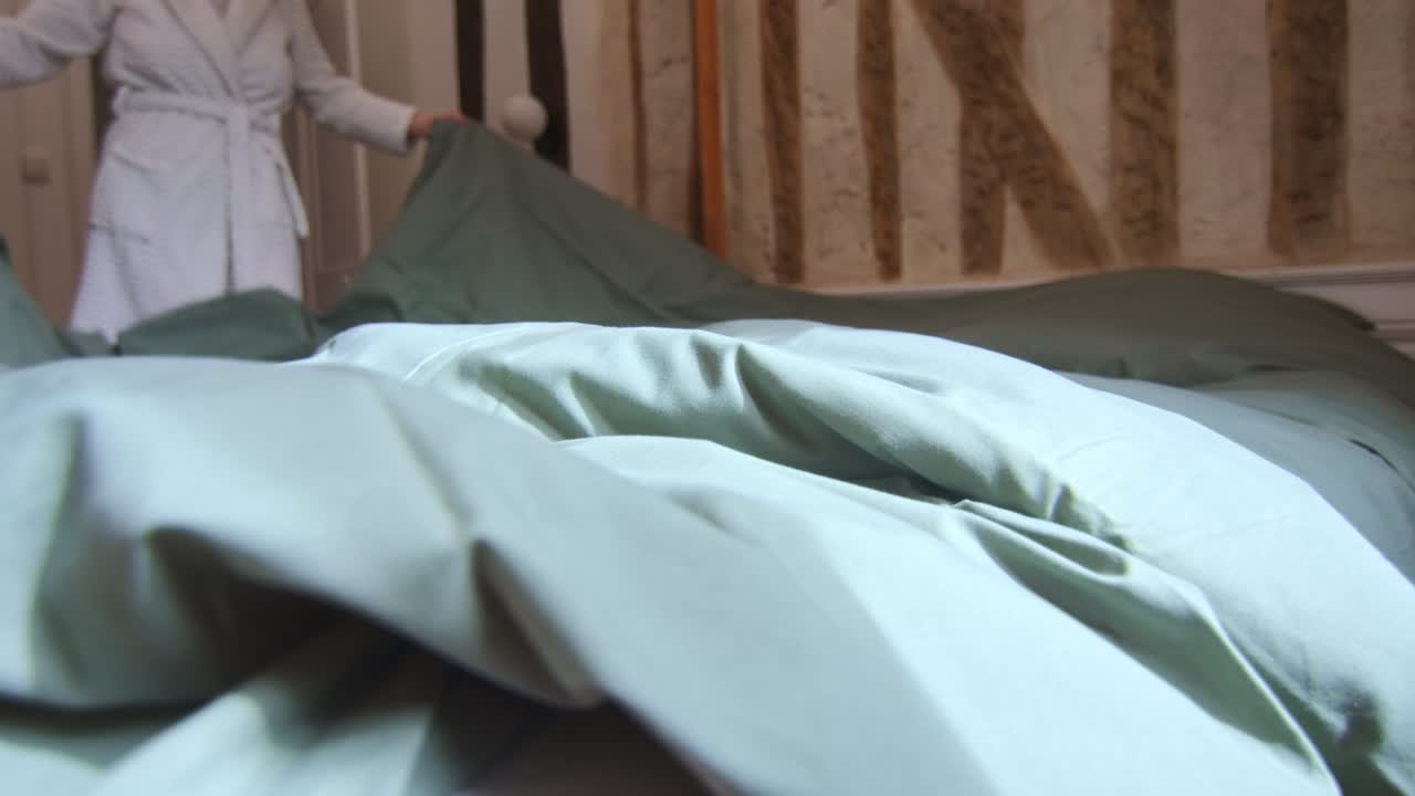 Unrecognizable Woman Making Bed After Getting Up In The Morning. Close-up Shot