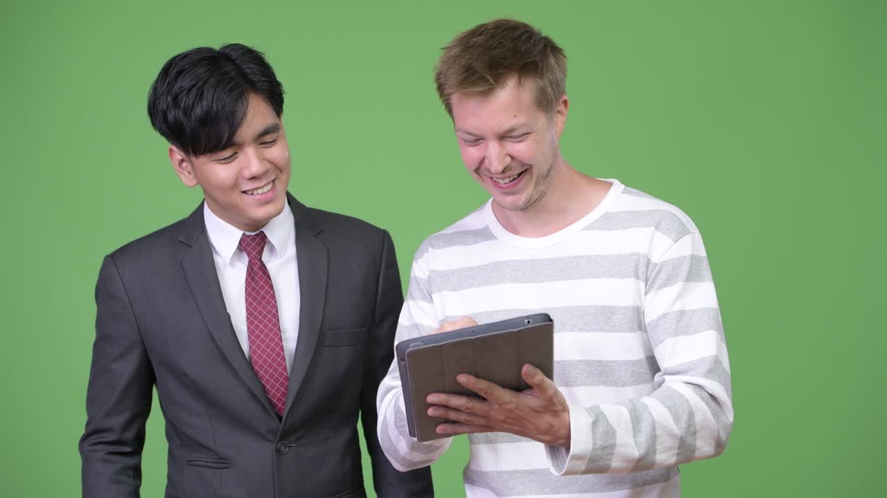 젊은 잘생긴 아시아 사업가와 젊은 스칸디나비아 사업가가 함께 일하고 있습니다.