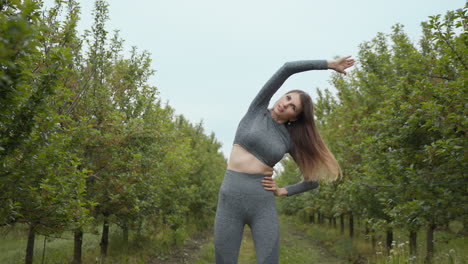 woman stretching in an orchard