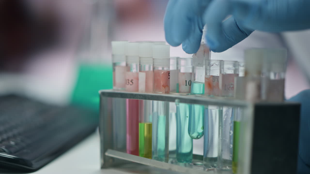 Medicine worker hands taking test tubes at experiment in laboratory close up.