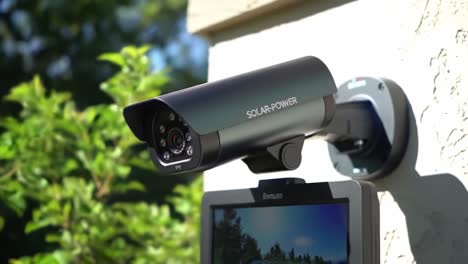 this clip showcases the installation of a solar-powered security camera on the exterior of a home. the device is mounted for optimal visibility and monitoring of the area, ensuring safety.