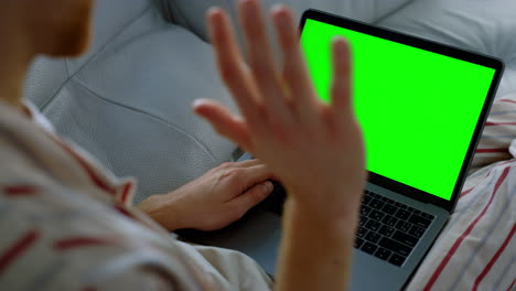 Man-talking-green-laptop-resting-on-sofa-closeup.-Teacher-having-online-lecture