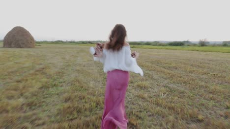mujer corriendo en un campo al atardecer