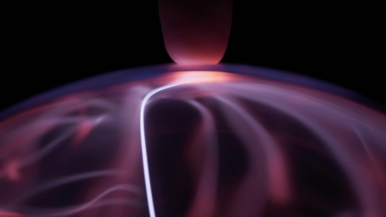 Un dito che tocca una sfera al plasma, creando raggi di energia. Movimento lento.