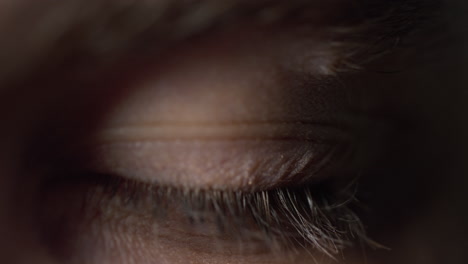 close up of opened male blue eye. macro video of concentrated young man.