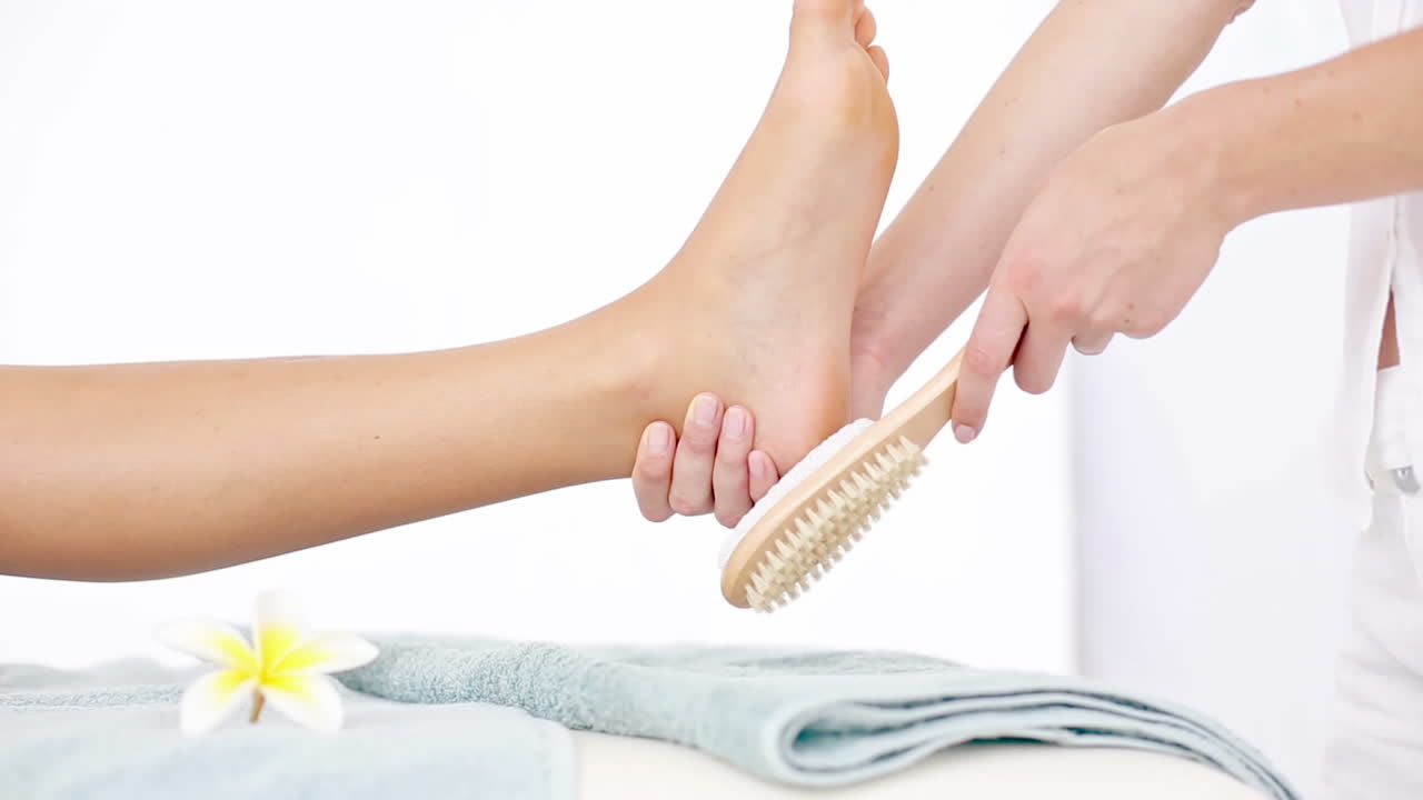 Pedicurista che pulisce il piede di una donna
