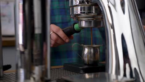 espresso oscuro rico que se vierte de la máquina