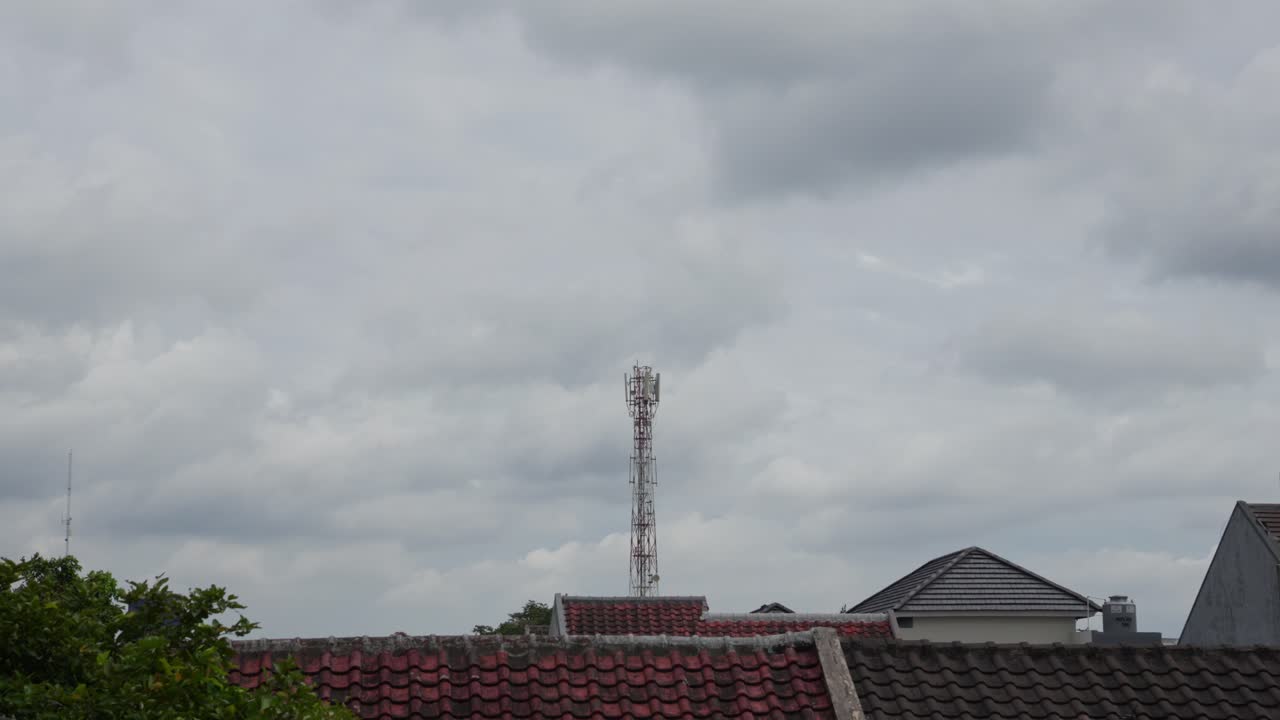 Clouds drifting above rooftops in a calm neighborhood timelapse view