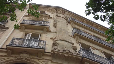 Looking-Up-On-The-Huge-Angel-Caryatid-Facade-Of-Rue-de-Turbigo,-Decorating-Exterior-Of-A-Haussmann-Style-Building-In-3rd-Arrondissement-Of-Paris-In-France