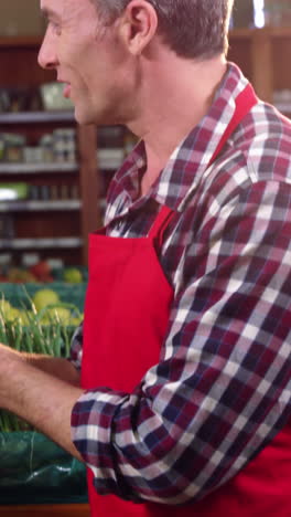 smiling male staff assisting a woman with grocery shopping