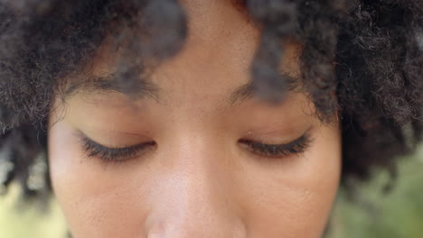 close-up of woman's eyes with curly hair, expressing warmth and joy