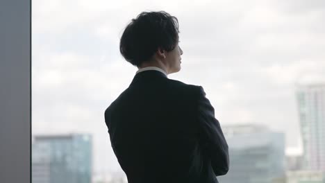 portrait of asian businessman standing by the window