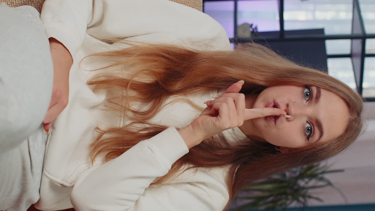 молодая женщина нажимает пальцем на губы делает молчание знак тишины не говорит сплетни секрет, тишина дома