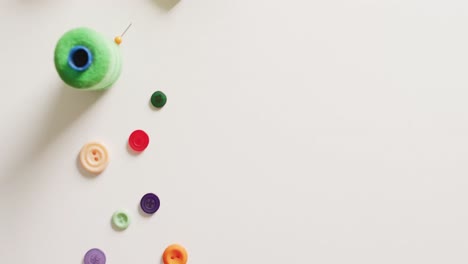 video of tape measure, scissors, buttons, pins and cotton reels on white background with copy space