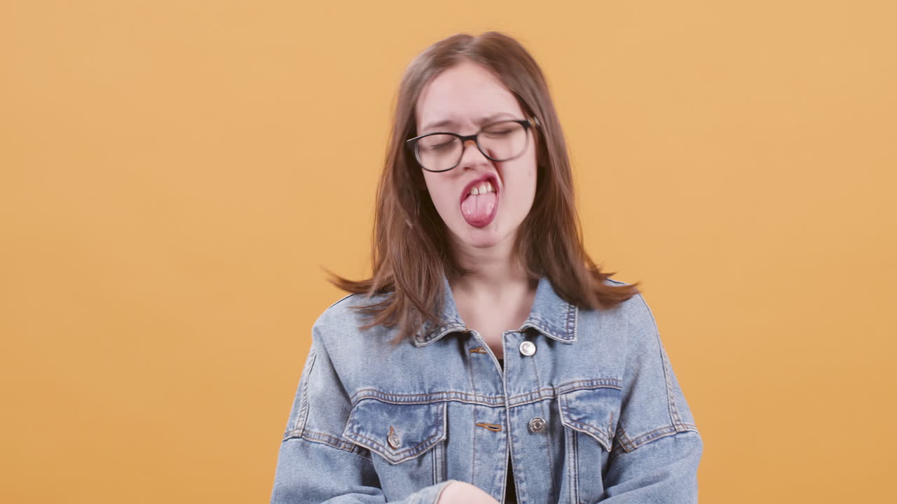 Young woman in denim jacket making facial expressions