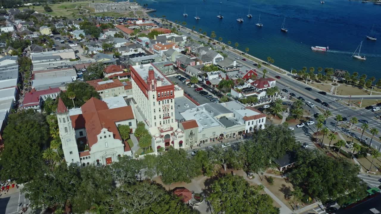 Edifícios históricos e uma área à beira-mar com barcos ancorados ao longo da costa são vistos no centro de St. Augustine, Flórida, mostrando elementos urbanos e naturais se encontrando na costa