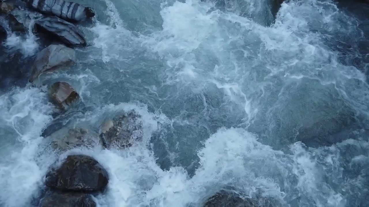 Forte corrente di acqua di disgelo che colpisce le rocce formando rapide di acqua bianca, vista aerea dall'alto. Ripresa in movimento del forte flusso d'acqua glaciale del fiume Kander nelle Alpi svizzere della Kandertal, Svizzera.