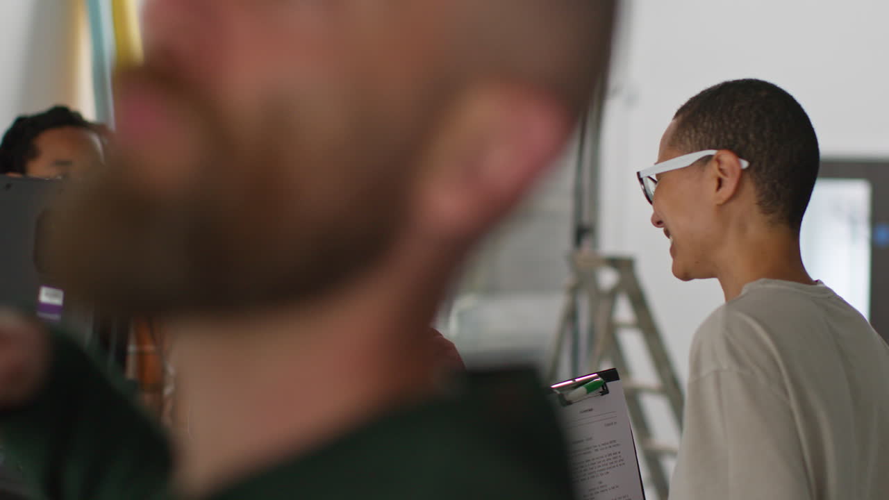 여성 영화 감독은 촬영장에서 촬영하는 영화 또는 비디오를 스튜디오에서 카메라맨, 사운드 레코더 및 조수와 함께 촬영합니다.