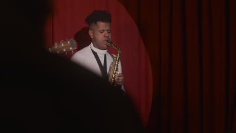 latin man playing sax and man playing guitar during live music perfomance 1