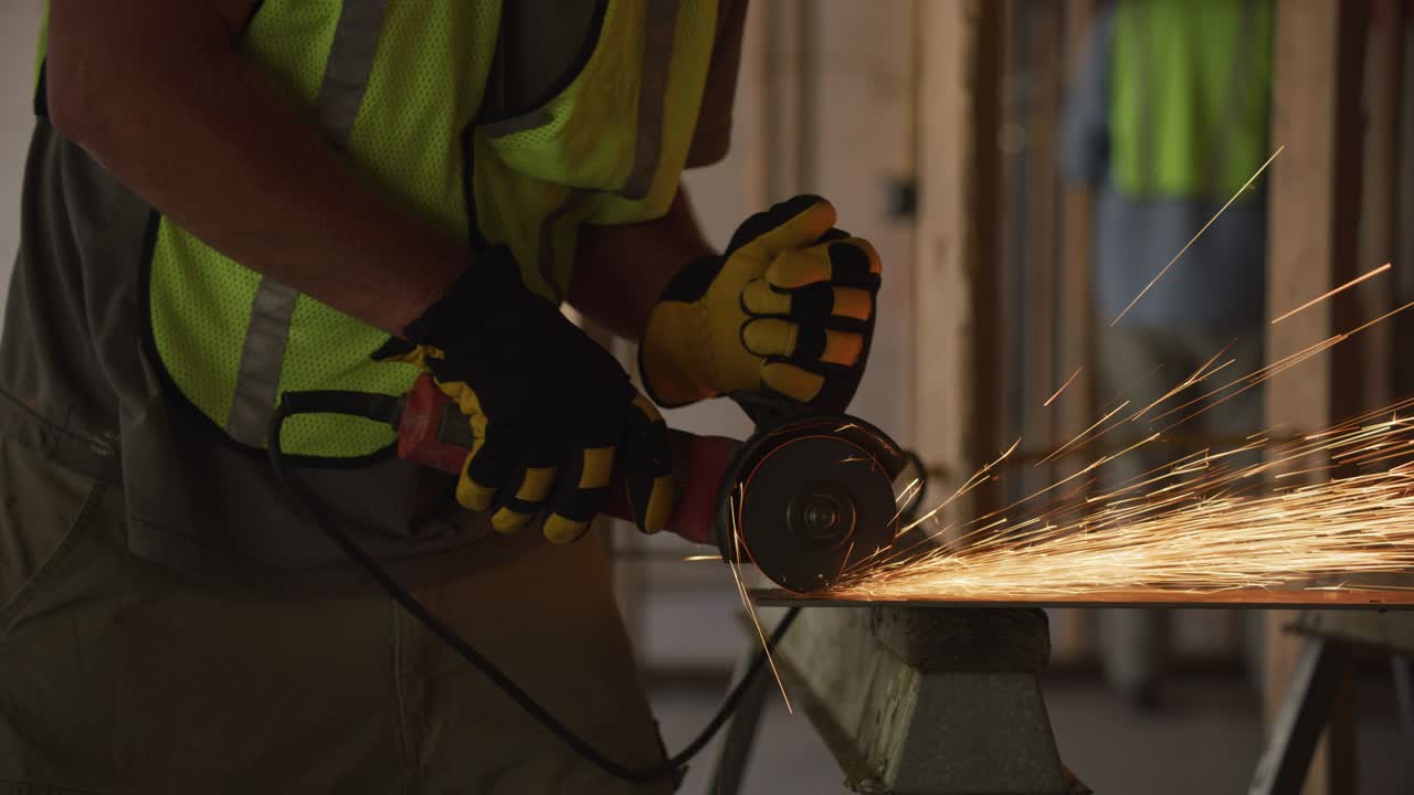 trabajador de la construcción moliendo metal y haciendo chispas, primer plano