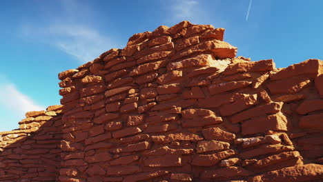 Panning-shot-of-old-historical-tower-Wukoki-Pueblo-under-blue-sky