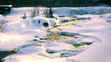 Cold water stream formed by melting away the snow covering the land of Saguenay,  Chicoutimi, Quebec, Canada. Slow motion.
