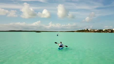 kayakista remando en el océano frente a la costa de providenciales en el archipiélago de turks y caicos